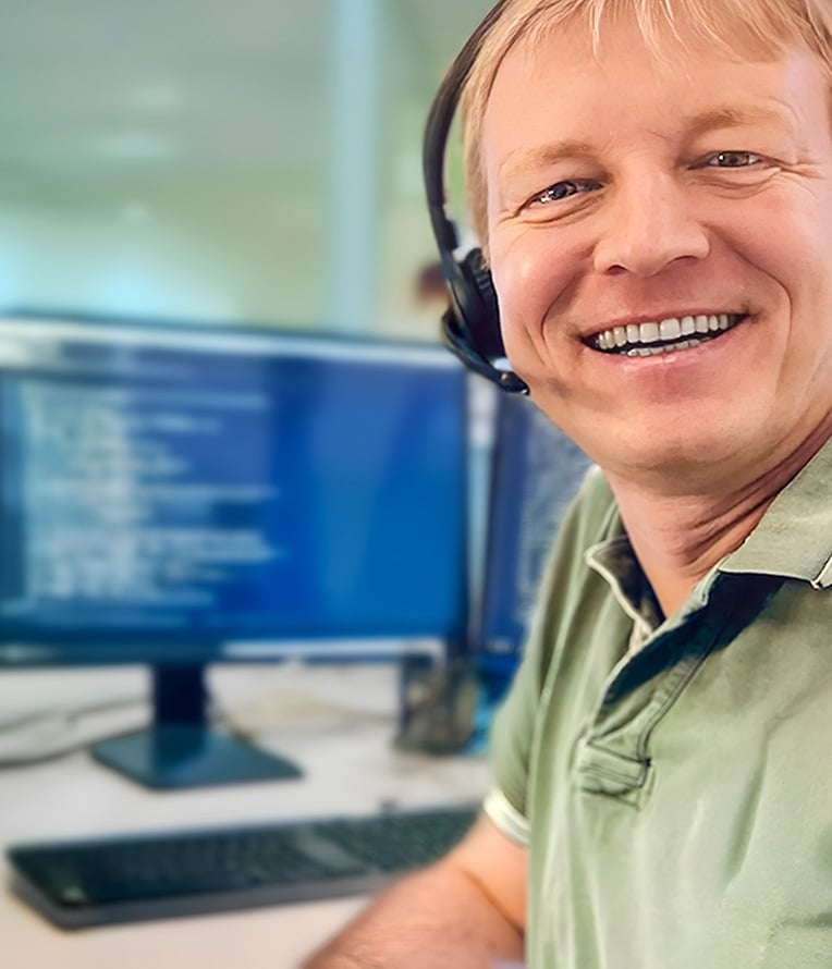 Webinar TMP, Marc Tscheuschner sitzt vor einem Monitor und trägt ein Headset. Team Management System.